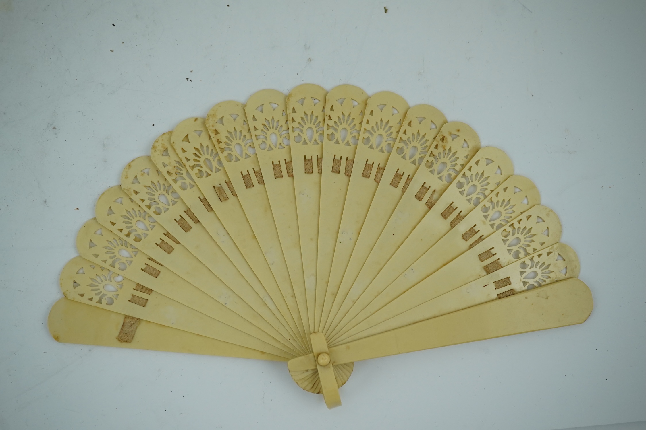 Three novelty fans with a mixed Brussels lace fan and black lace fan, a small language of love in flowers fan, a paper windmill advertising French Café fan, a carved cream Bakelite fan, a black and gilt, lace and sequin